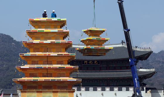 Workers install a monumental pagoda celebrating Buddha's Birthday at Gwanghwamun Square in Jongno District, central Seoul, on March 31. [YONHAP]