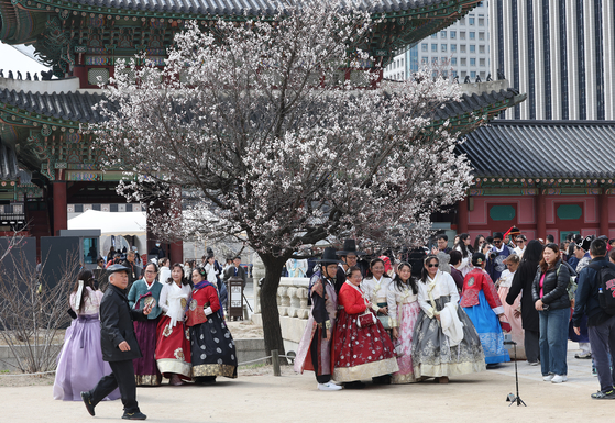 Tourists take pictures inside Gyeongbok Palace in Jongno District, central Seoul, on March 30. [YONHAP]