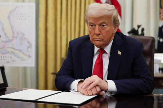 U.S. President Donald Trump prepares to sign an executive order related to the U.S. live entertainment ticketing industry in the Oval Office at the White House in Washington on March 31. [REUTERS/YONHAP]