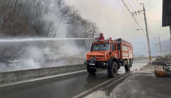 A high-performance fire extinguishing truck disperses water on flames in Andong City in North Gyeongsang on March 25. [KOREA FOREST SERVICE] 