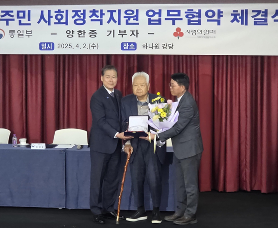 Unification Minister Kim Yung-ho, left, donator Yang Han-jong, center, and his stepson posing for a photo after a ceremony at Hanawon in Anseong, Gyeonggi , on April 2. [YONHAP] 