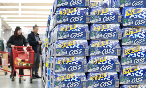 Cass beer packs are shown by customers shopping at a wholesale store in Seoul on March 30. [NEWS1]
