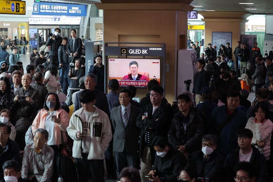 Citizens watch the live broadcast of the Constitutional Court's impeachment trial verdict in the waiting room of Seoul Station in Yongsan District, central Seoul, on April 4. [NEWS1]