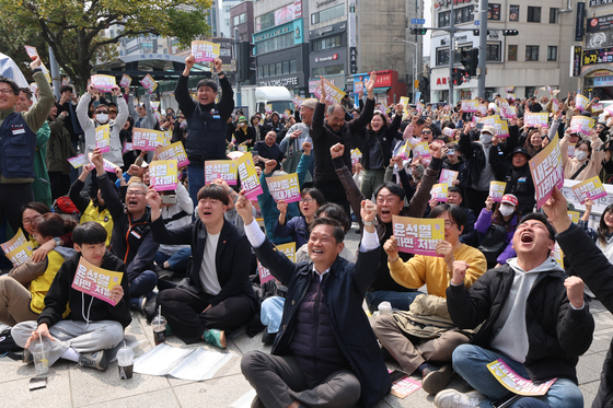 People cheer near Jeju City Office on April 4 after the Constitutional Court, in a historic ruling, upheld a decision to impeach President Yoon Suk Yeol. [YONHAP]