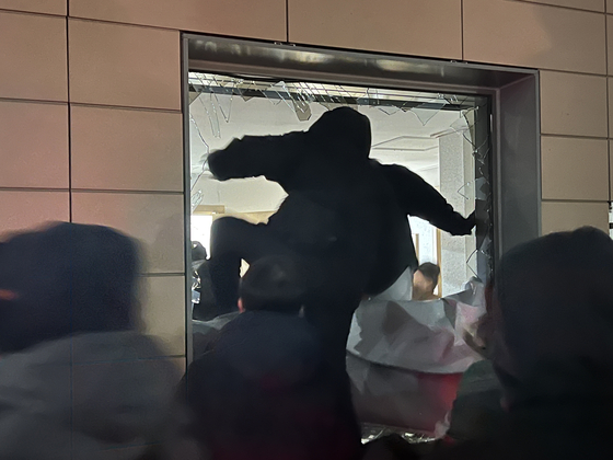 An unidentified man enters the Seoul Western District Court through a broken window in Mapo District, western Seoul, on Jan. 19, after the court grants an arrest warrant for President Yoon Suk Yeol.[NEWS1]