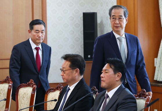 Acting President Han Duck-soo, right, enters a National Security Council (NSC) meeting held at the government complex in central Seoul on April 4, trailed by National Security Adviser Shin Won-sik. [YONHAP] 
