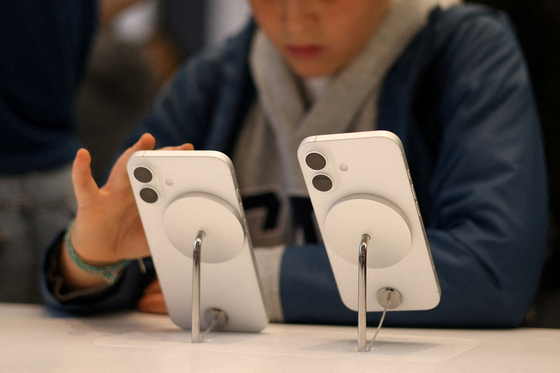 A child uses an Apple iPhone smartphone displayed at a store in London on Oct. 6, 2024. [REUTERS/YONHAP]