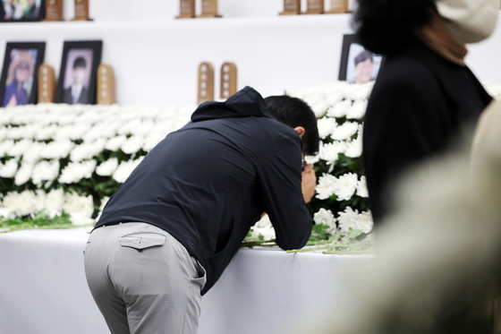 Families of the victims of the Jeju Air crash weep at a memorial altar set up at the Muan Airport South Jeolla on April 5. [YONHAP]