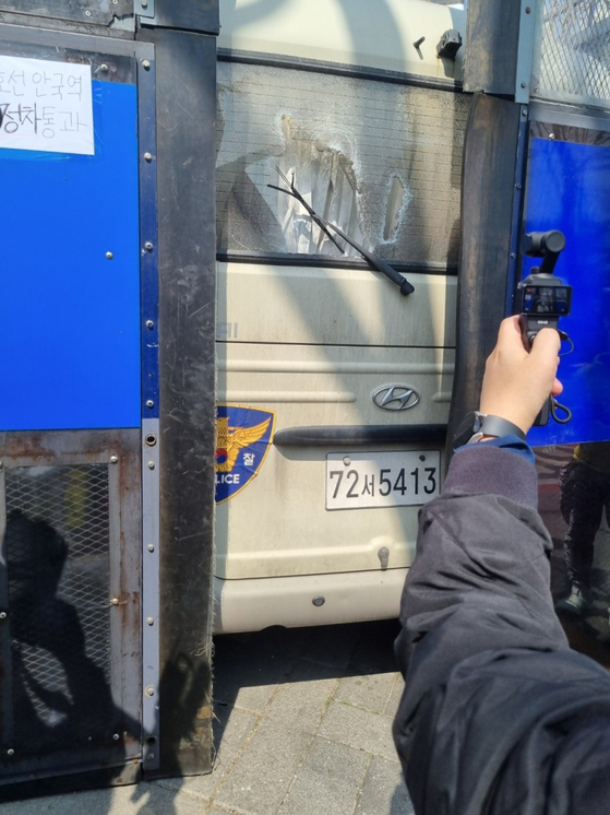 A glass window on a police bus lies shattered near Anguk Station in central Seoul after a pro-Yoon Suk Yeol protesters smashed it after hearing the Constitutional Court's ruling on April 4. [KIM MIN-YOUNG]