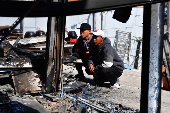 Indonesian fisher Sugianto, right, on March 31 explains the happenings of the day that his neighborhood burned down due to the wildfire in Yeongdeok County in North Gyeongsang on March 25. [NEWS1]
