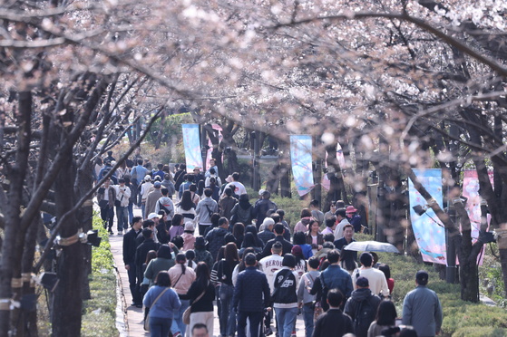 People walk in Seokchon Lake Park in southern Seoul on April 3. [NEWS1] 
