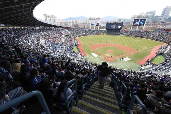 Fans watch a KBO game between the Doosan Bears and Samsung Lions at Jamsil Baseball Stadium in southern Seoul on March 30. [YONHAP] 