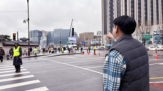 Lee Dong-jun, 53, who was born and raised in Hyoja-dong in Jongno District, central Seoul, points to the rally site in front of Gyeongbok Palace on the April 5. [LEE AH-MI]
