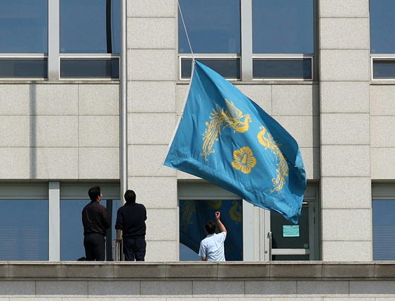 The Phoenix flag hanging at the presidential office building in Yongsan District, central Seoul, is being taken down by presidential office officials after the Constitutional Court upheld the impeachment of President Yoon Suk Yeol on April 4. [PRESIDENTIAL OFFICE]