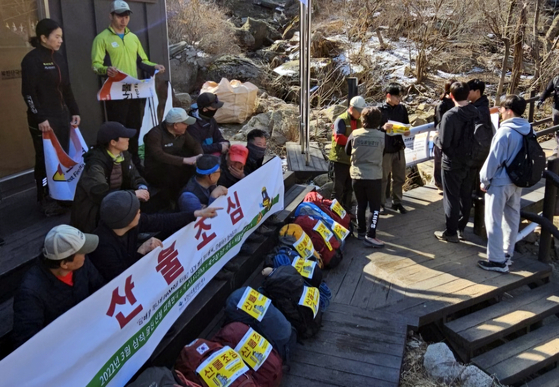 Officials from Bukhansan National Park and members of a mountain safety advocacy group conduct a wildfire prevention campaign along a hiking trail in Bukhansan National Park, Eunpyeong District, northern Seoul, on March 30. [YONHAP] 