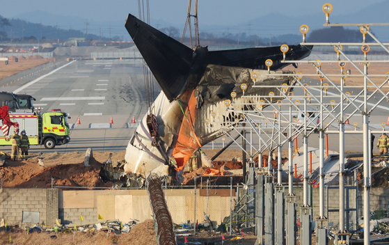 A tail section of Jeju Air's crashed aircraft is tied to a crane at Muan International Airport in South Jeolla on Jan. 3. [NEWS1]