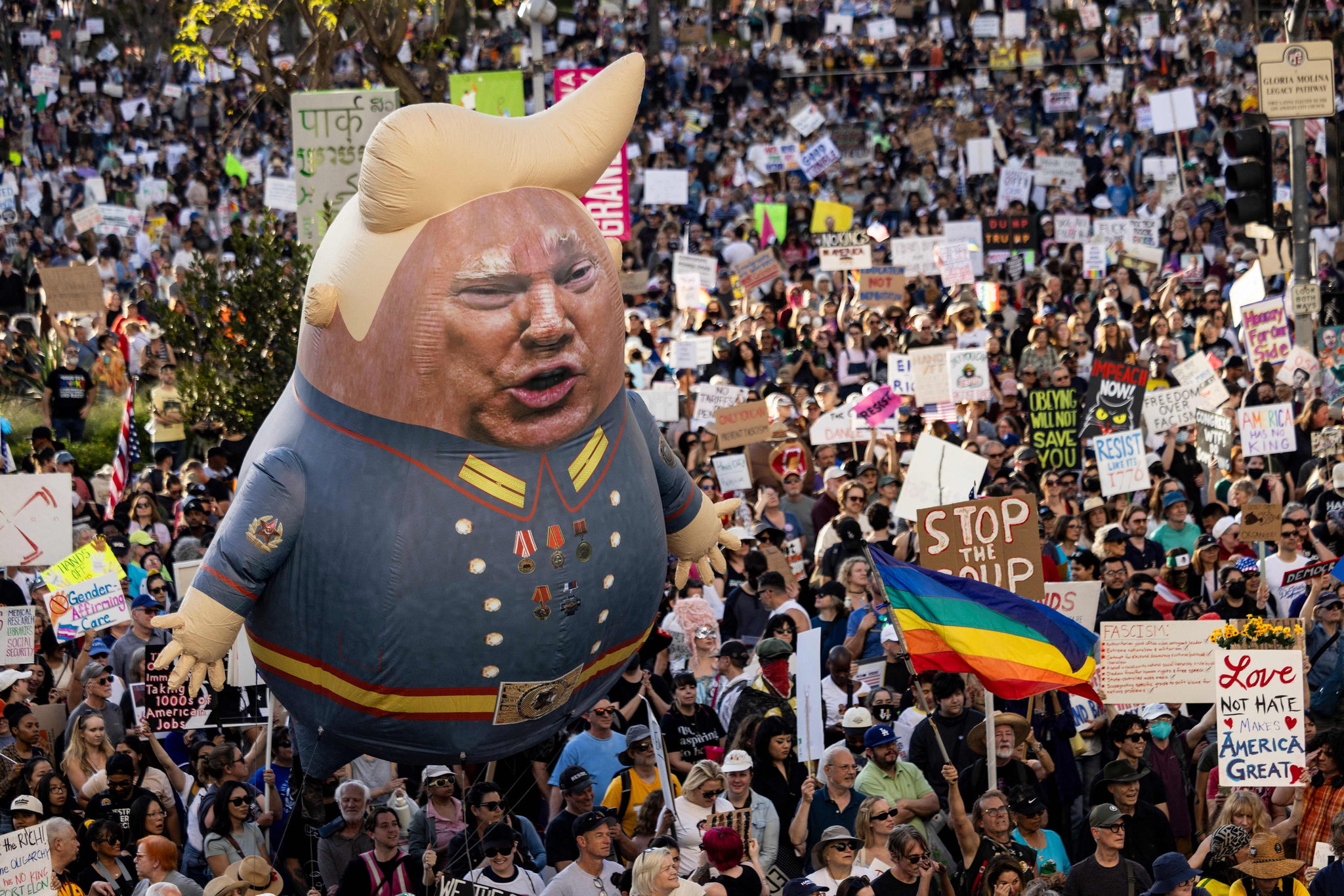 A large balloon with an image of U.S. President Donald Trump is seen above protesters holding signs during the nationwide ″Hands Off!″ protest against Trump and his advisor, Tesla CEO Elon Musk, in downtown Los Angeles on April 5. Protesters flooded the streets of several major U.S. cities to oppose the divisive policies of President Donald Trump, in the largest demonstrations since his return to the White House. [AP/YONHAP] 