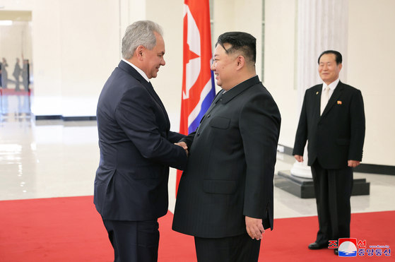 This file photo, carried by North Korea's official Korean Central News Agency on March 22, shows the North's leader Kim Jong-un, right, shaking hands with Sergei Shoigu, secretary of Russia's Security Council, in Pyongyang the previous day. [KOREAN CENTRAL NEWS AGENCY] 