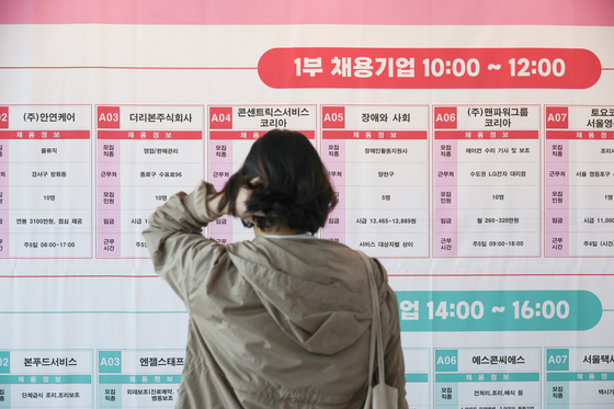 A person looks at job postings at a job fair in Yangcheon District, western Seoul, on April 1. [YONHAP] 