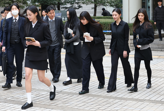 Members of girl group NewJeans leave the Seoul Central District Court building in southern Seoul on March 7 after taking part in the injunction case against their agency ADOR. [YONHAP]