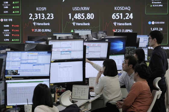Currency traders watch monitors near a screen showing the Korea Composite Stock Price Index, top left, and the foreign exchange rate between dollar and Korean won, top center, at the foreign exchange dealing room of the KEB Hana Bank headquarters in central Seoul on April 9. [AP/YONHAP] 
