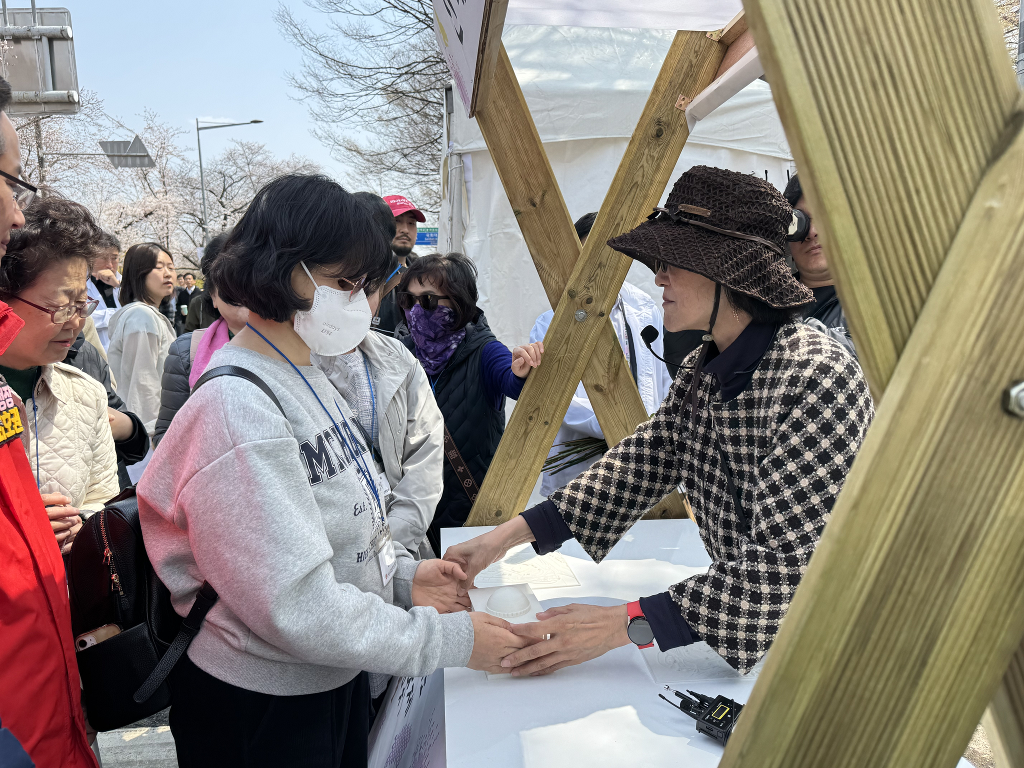 A tour participant touches 3D models of the National Assembly during Yeongdeungpo District's annual Spring Flower Festival in Yeouido, western Seoul, on April 8. [CHO JUNG-WOO] 