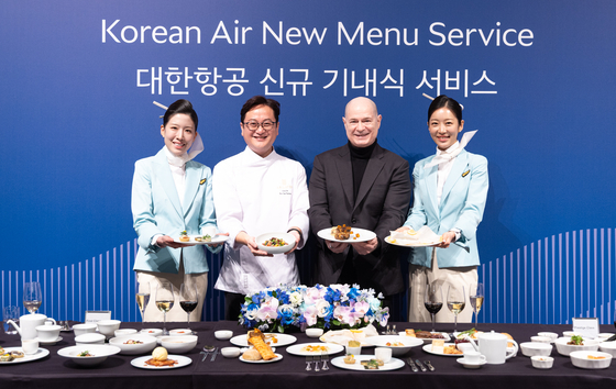 David Pacey, second from right, vice president of Korean Air's in-flight catering and lounge division, introduces the airline’s new in-flight meal service with chef Seakyeong Kim, third from right, who participated in meal development, at the Grand Hyatt Incheon on March 11. [KOREAN AIR]