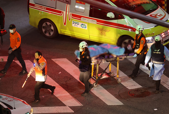 Emergency respondent moving bodies from Itaewon, Seoul, on Oct. 29, 2022. [YONHAP]