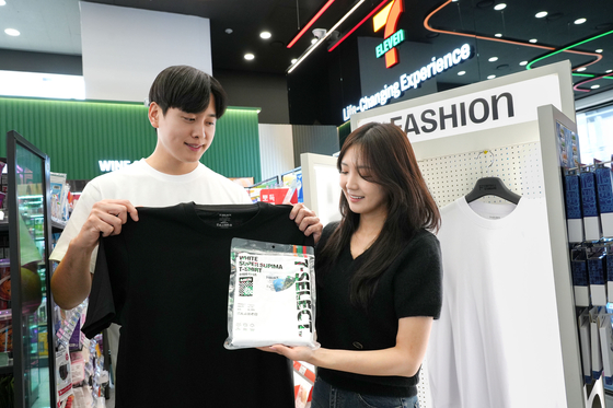Advertising models hold up convenience store chain 7-Eleven's new 7-Select T-shirts that will be sold from April 9. [7-ELEVEN]