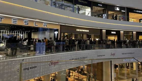 A crowd is lined up in front of a Tesla store in Starfield Mall in Hanam, Gyeonggi, on March 28. [SCREEN CAPTURE]