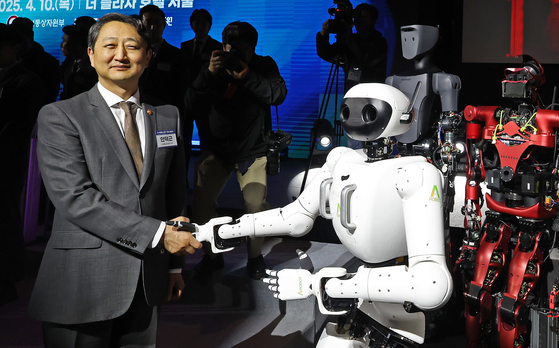 Minister of Trade, Industry and Energy Ahn Duk-geun shakes hands with A Robot at the K-Humanoid Alliance launch at the Plaza Hotel in central Seoul on April 10. [NEWS1]