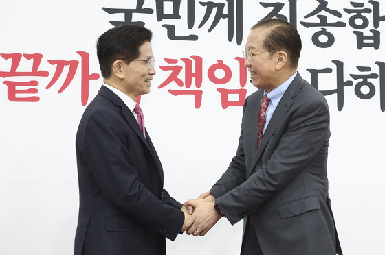 Ex-Labor Minister Kim Moon-soo, left, is welcomed by conservative People Power Party (PPP) interim leader Kwon Young-se at the National Assembly in western Seoul on April 9. Kim visited the parliament to join the PPP. [LIM HYUN-DONG]