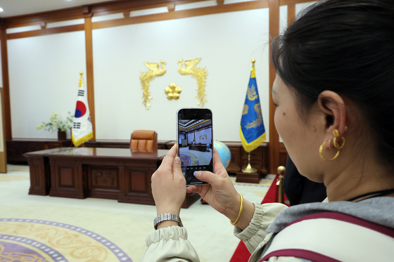 A visitor takes a photo of former presidential workspace at Blue House in Jongno District, central Seoul on April 9. After impeached President Yoon Suk Yeol relocated the presidential office to Yongsan District, Blue House has been opened to the public. [NEWS1] 