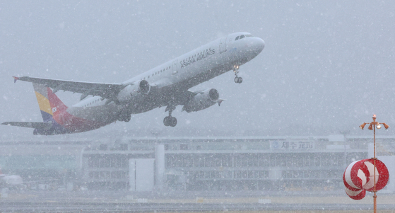 A plane takes off through a snowstorm at Jeju International Airport in Jeju on Feb. 7. [YONHAP] 