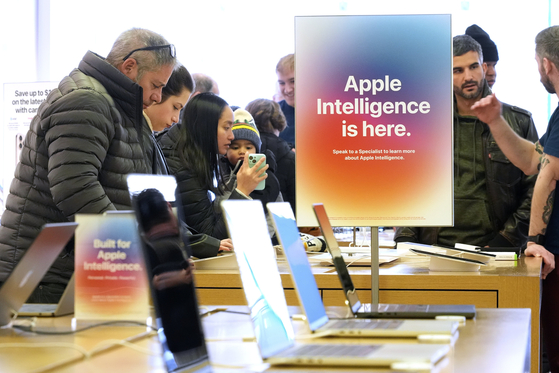 People gather around a table of iPhones at an Apple Store in Pittsburgh on Jan. 8. [AP/YONHAP]