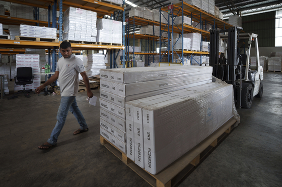 An employee inspects stocks before they are loaded onto a container for shipping to the U.S. at Corporate Specialist’s furniture factory on the outskirts of Muar, in Johor state of Malaysia on April 11. [AP/YONHAP] 