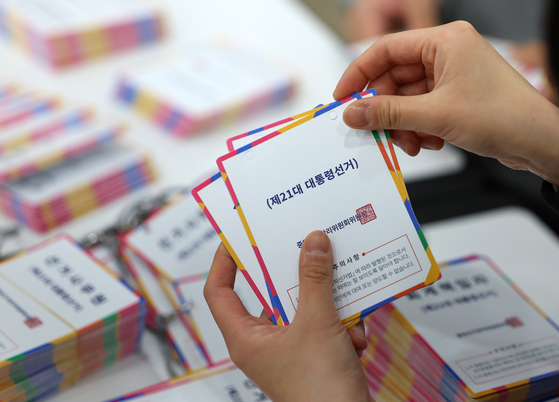 Staff at the National Election Commission in Gwacheon, Gyeonggi, organize identification tags for election officials on April 14. [YONHAP]