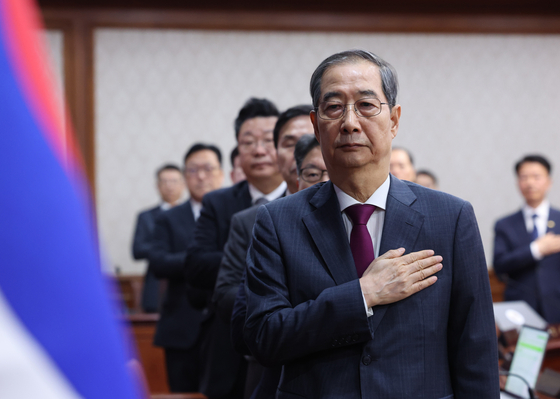 Acting President and Prime Minister Han Duck-soo makes a gesture of allegiance during a Cabinet meeting at the Government Complex in central Seoul on April 14. [YONHAP]