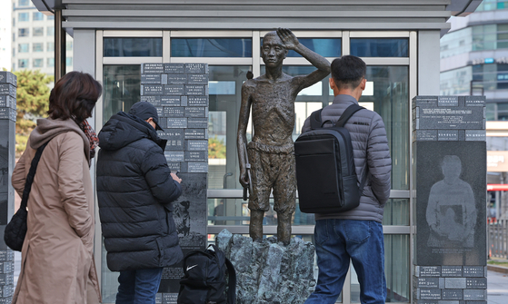 Citizens on Nov. 24, 2024, walk by a statue in Yongsan Station square, central Seoul, erected to remember victims of forced labor by Imperial Japan during WWII. [NEWS1]