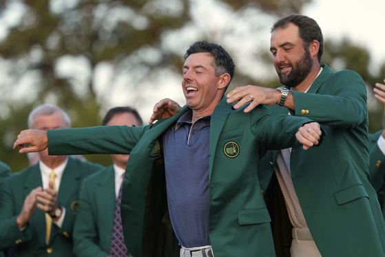 Scottie Scheffler puts the green Jacket on winner Rory McIlroy at the Masters in Augusta, Georgia on April 13.  [AP/YONHAP]