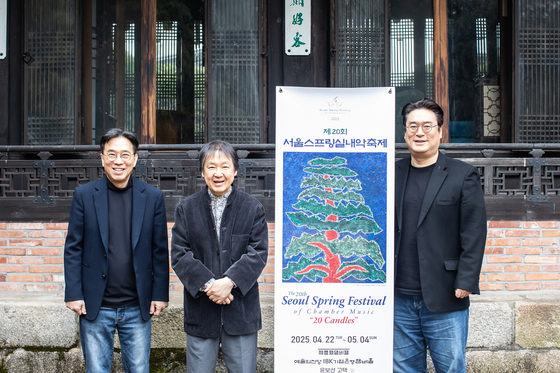 Violnist Kang Dong-seok, center, who has served as the artistic director of Seoul Spring Festival of Chamber Music for the past 20 years as well as violist Kim Sang-jin, right, and pianist Kim Young-ho, left, pose for a photo next to the promotional poster for the forthcoming festival at the residence of former president Yun Po-sun on April 14 in central Seoul. [SEOUL SPRING FESTIVAL OF CHAMBER MUSIC]