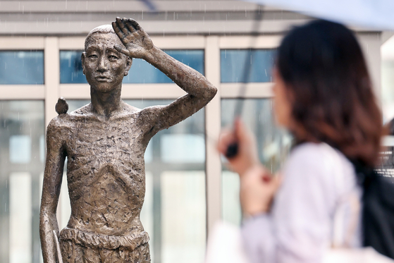 A pedestrian on Sept. 12, 2024, walks by a statue in Yongsan Station square, central Seoul, erected to remember victims of forced labor by Imperial Japan during WWII. [NEWS1]