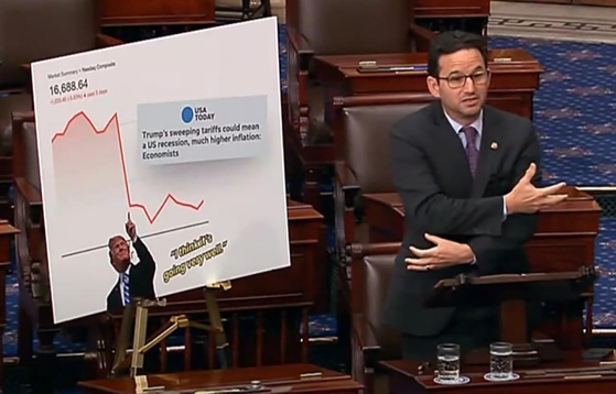 Democratic Sen. Brian Schatz of Hawaii reenacts a photo of Korean Trade Minister Ahn Duk-geun, holding hands with Japanese and Chinese counterparts during a Senate floor speech on April 4. He referenced a photo taken at a Korea-Japan-China trade ministers’ meeting on March 30. [SCREEN CAPTURE]