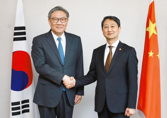 Korea's Minister of Trade, Industry and Energy Ahn Duk-geun, right, shakes hands with China's Minister of Commerce Wang Wentao on March 29, ahead of the 13th Trilateral Economic and Trade Ministers' Meeting between Korea, China and Japan in Seoul. [YONHAP]