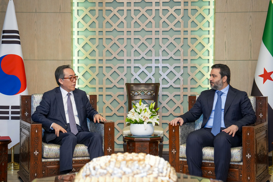 South Korean Foreign Minister Cho Tae-yul, left, and his Syrian counterpart Asaad al-Shaibani, right, converse before formally signing the documents for a diplomatic relationship agreement between the two countries in Damascus on April 10. [MINISTRY OF FOREIGN AFFAIRS]