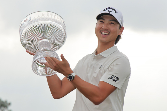 Min Woo Lee celebrates with the trophy after winning the Texas Children's Houston Open at Memorial Park Golf Course in Houston, Texas on March 30. [GETTY IMAGES] 