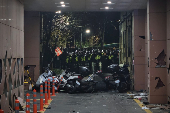 A barricade made of motorcyles is set up at the Seoul Western District Court on the early morning of Jan. 19, after protesters stormed the court. Police arrested 46 individuals on the scene. [JOONGANG ILBO]