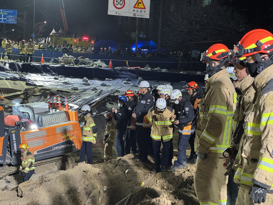 Officials from the fire authorities observe members of the Gyeonggi Fire and Disaster Headquarters' Special Response Unit as they recover the body of a man killed in the Shinansan Line tunnel construction site collapse in, Gwangmyeong, Gyeonggi on April 16. [GYEONGGI FIRE DEPARTMENT]