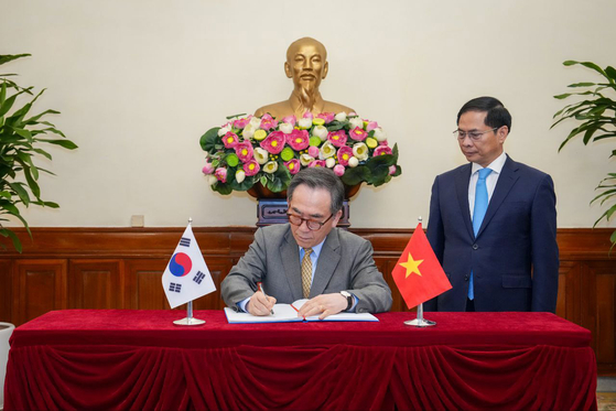 South Korean Foreign Minister Cho Tae-yul signs a document as Vietnamese Deputy Prime Minister and Foreign Minister Bui Thanh Son looks over during a bilateral meeting in Hanoi on April 15. [NEWS1]