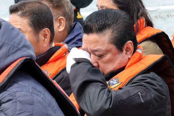 A family member of a Sewol ferry victim wipes his tears at a memorial held at Jindo County, South Jeolla, on April 16. [YONHAP] 
